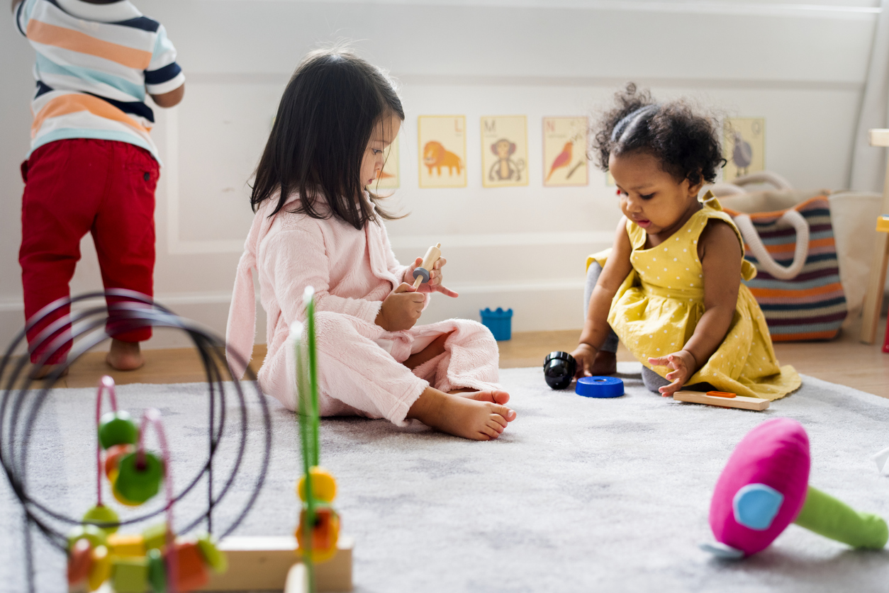 Three toddlers playing with toys