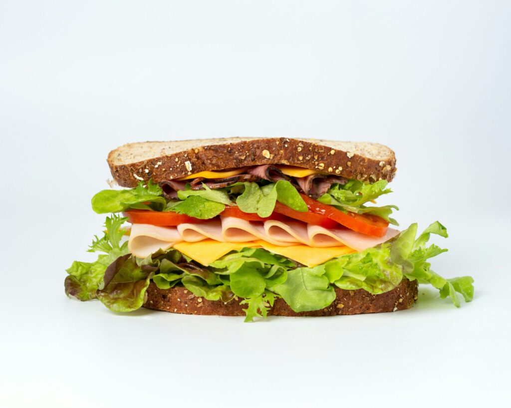 A sandwich with meat, cheese, lettuce, tomato