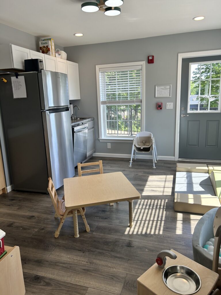 Interior of Stay & Play Child Care Center showing fridge, kitchen, and handwashing sink