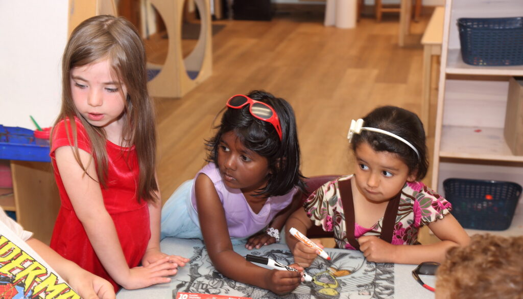 Three young girls with coloring books at Rutland County Parent Child Center