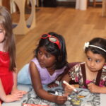 Three young girls with coloring books at Rutland County Parent Child Center