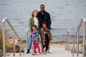 Two parents and two young children smiling