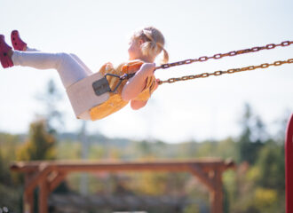 Young child swinging high on swing