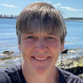 Close up photo of Dr. Debra Hartswick with blue water in the background