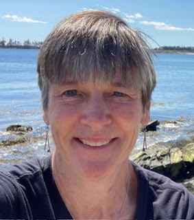 Close up photo of Dr. Debra Hartswick with blue water in the background