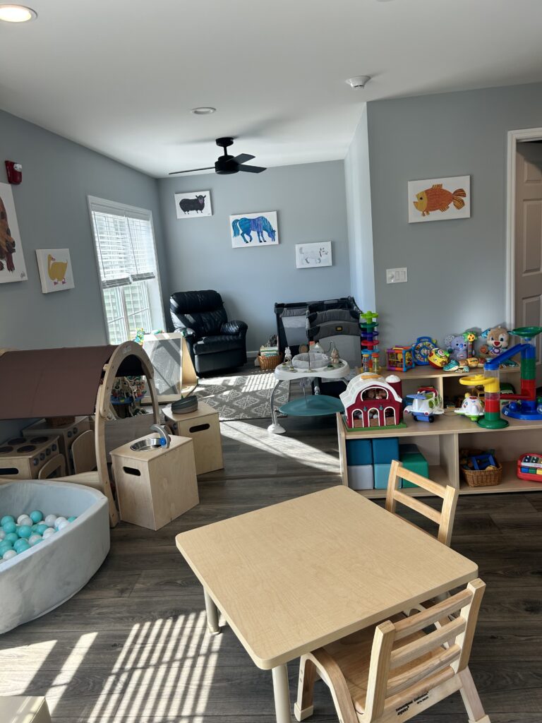 Interior of Stay & Play Child Care Center showing toys, tables, chairs, and colorful illlustrations on the walls