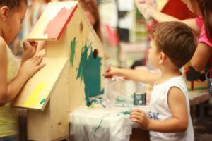 A preschooler painting a bird house