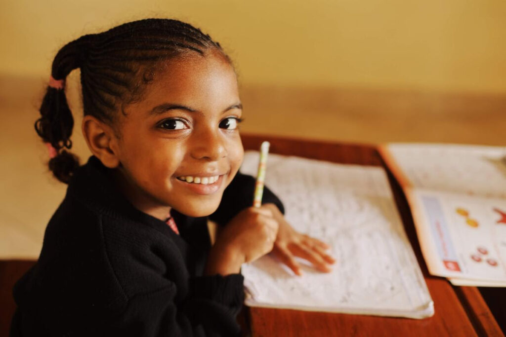 Young student smiling and holding a pencil