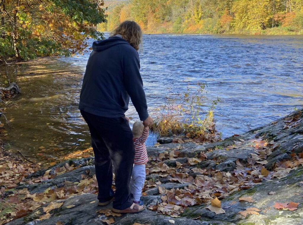 Parent and small child by river